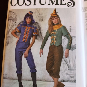May include: McCall's Costumes pattern featuring two costume designs. One costume is a blue outfit with orange zig-zag trim, the other is a green jacket and brown pants. The pattern includes the text "COSTUMES" and the McCall's logo.