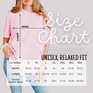 Op de afbeelding: Een lichtroze unisex T-shirt met een maattabel overlay. De tabel geeft de afmetingen in inches voor breedte, lengte en mouw middenachter voor maten S t/m 4XL. Het shirt is een Comfort Colors adult heavyweight T-shirt, unisex, relaxed fit.