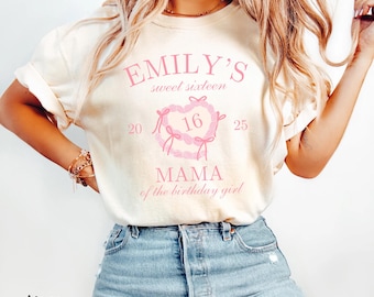 May include: Ivory t-shirt with pink text that reads "EMILY'S sweet sixteen 20 16 25 MAMA of the birthday girl". The text is in a heart shape with a pink ribbon design.