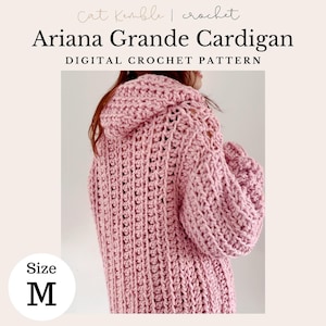 Op de afbeelding: Een roze gebreide cardigan met een capuchon. De cardigan is maat M.