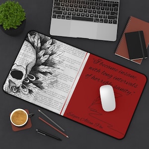 May include: A rectangular desk mat featuring a split design. The left side displays a black and white illustration of a skull with feathers over a background of printed text. The right side is solid red with the text "I became insane, with long intervals of horrible sanity." and "Edgar Allan Poe" in black script.