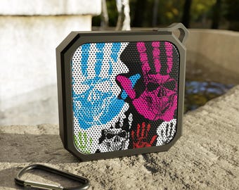 Altavoz Bluetooth para exteriores de colores vibrantes con diseño de mano de calavera.