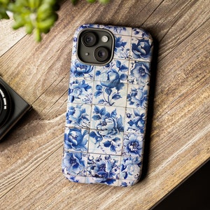 Könnte beinhalten: Eine blaue und weiße Handyhülle mit einem Blumenmuster. Die Hülle hat einen Ausschnitt für das Kameraobjektiv und einen weißen Rand.