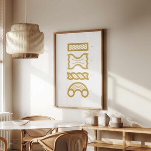May include: A framed print with a white background and gold illustrations of different types of pasta. The pasta shapes are labeled with their names in a small font.