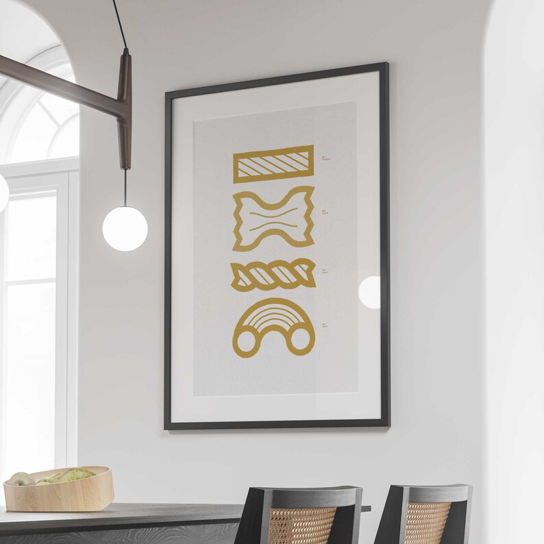 May include: A framed print with a white background and four gold pasta shapes. The shapes are a long rectangle with stripes, a bowtie, a twisted rope, and a rainbow.