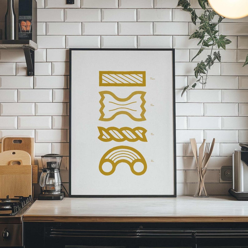 May include: A black framed print with a white background and gold illustrations of different types of pasta. The pasta shapes include a bowtie, a long noodle, a short noodle, and a spiral noodle.