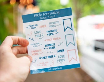 May include: A sticker sheet with blue and pink stickers for bible journaling. The stickers have phrases like "Favorite Verse", "Love This", "Amen", and "Take Note".