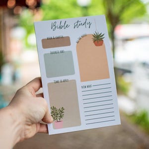 May include: A white Bible study notepad with the words "Bible study" at the top. The notepad has sections for notes, including "Book & Chapter," "Favorite Part," and "Time to Apply." Decorative elements include potted plants and the phrase "All the Notes."