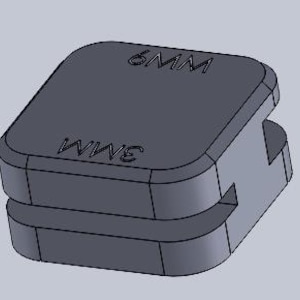 May include: A dark grey, square component with rounded edges. The top surface is marked "6MM" and the side with "3MM". The object is a small, possibly 3D-printed, part with a slot cut into its side.