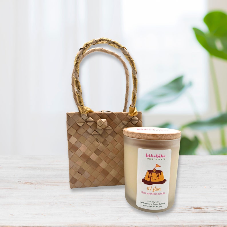 Leche flan soy candle in a glass jar . #1 Flan isa  heavenly blend of eggy, custardy goodness harmonizing with the rich flavors of condensed milk, a dash of vanilla, and luscious caramelized sugar. Comes with a Philippine made handwoven pandan bag.