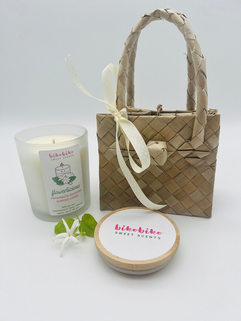 Sampaguita (jasmine) soy candle is sweet, heavenly, and so flowerlicious! Captures the  essence of the national flower of the Philippines symbolizing purity, faith, and love. Comes in a 7 oz glass jar with bamboo lid and packaged in a handwoven bag.