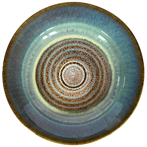 May include: A ceramic bowl with a concentric spiral design. The bowl features a gradient of colors, including shades of blue, brown, and cream. The rim has a darker brown edge. The bowl's interior has a glossy finish.