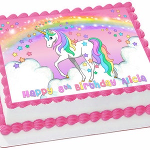 May include: A rectangular birthday cake with white frosting and pink trim. The top features a colorful image of a unicorn, rainbow, and stars. Text reads "Happy 8th Birthday Alicia".
