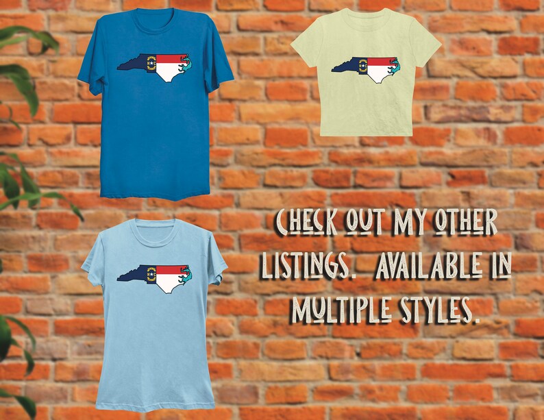 May include: Three t-shirts featuring a North Carolina state outline with the state flag and a blue anchor. The shirts are in blue, light blue, and light yellow. The text "CHECK OUT MY OTHER LISTINGS. AVAILABLE IN MULTIPLE STYLES." is below the shirts.