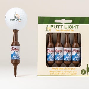 Pu&ograve; includere: Una pallina da golf bianca con il logo Putt Light &egrave; posizionata su un tee da golf marrone a forma di bottiglia di birra. Accanto, una scatola di cartone contiene quattro tee identici a forma di bottiglia, etichettati "Fores Light".