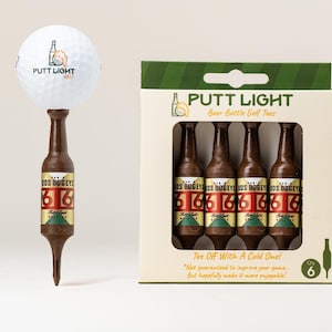 Pu&ograve; includere: Una pallina da golf bianca con il logo Putt Light Golf &egrave; posizionata sopra un tee da golf marrone a forma di bottiglia di birra. Accanto, una scatola di cartone contiene quattro tee identici a forma di bottiglia, etichettati Dos Bogeys e 6.