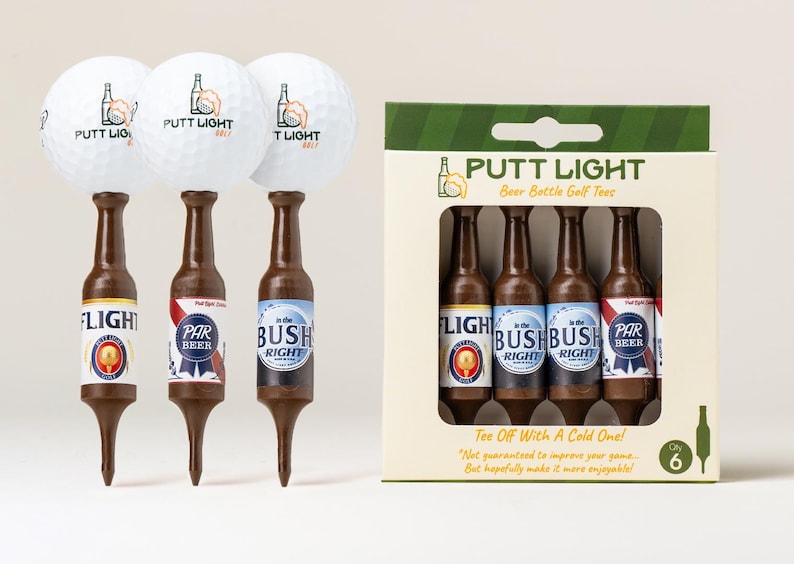 Pu&ograve; includere: Tre palline da golf bianche con il logo Putt Light, ciascuna appoggiata su un tee da golf marrone a forma di bottiglia di birra. Accanto c'&egrave; una scatola di cartone contenente sei di questi tee a forma di bottiglia, etichettati Putt Light.