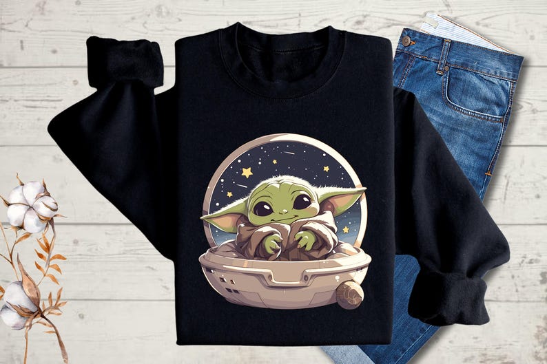 Puede incluir: Sudadera negra con un personaje alien&iacute;gena verde en una nave espacial, sobre un fondo de cielo nocturno estrellado.