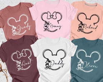 May include: Six t-shirts with a black and white outline of Mickey Mouse's head with the names "Grady", "Mommy", "Richard", "Aunt", "Daddy", and "Oliver" written inside the outline.