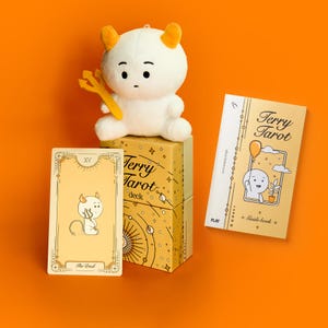 May include: A tarot deck set with a plush devil doll, a card, and a guide book. The deck box and guide book feature the text "Terry Tarot". The card shows a devil illustration, and the doll has horns and a pitchfork.