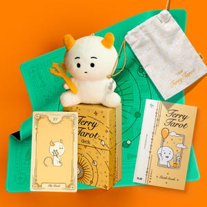 May include: A tarot card deck set with a plush devil figure, a drawstring bag, and a guidebook. The box and guidebook are light yellow with the words "Terry Tarot" and illustrations. The plush devil has orange horns and a trident.