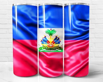 Puede incluir: Un vaso de acero inoxidable con un diseño de la bandera de Haití. La bandera es azul y roja con un escudo de armas en el centro. El escudo de armas presenta una palmera, cañones y las palabras "L'UNION FAIT LA FORCE".