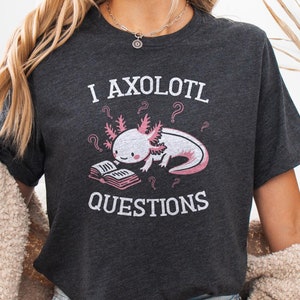 May include: Dark heather grey t-shirt with a pink axolotl reading a book and the text "I axolotl questions".