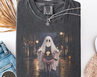 Ghost riding bike with cat holding biscuit Comfort Colors shirt, spooky season cat mom tee, funny Halloween cat dad gift, trick or treat tee