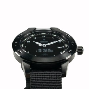 May include: A black wristwatch with a black nylon strap. The watch face is black with white markings and the text "BE BRAVE LIKE UKRAINE" and "UKRAINIAN MILITARY". The watch is water resistant to 100 meters.