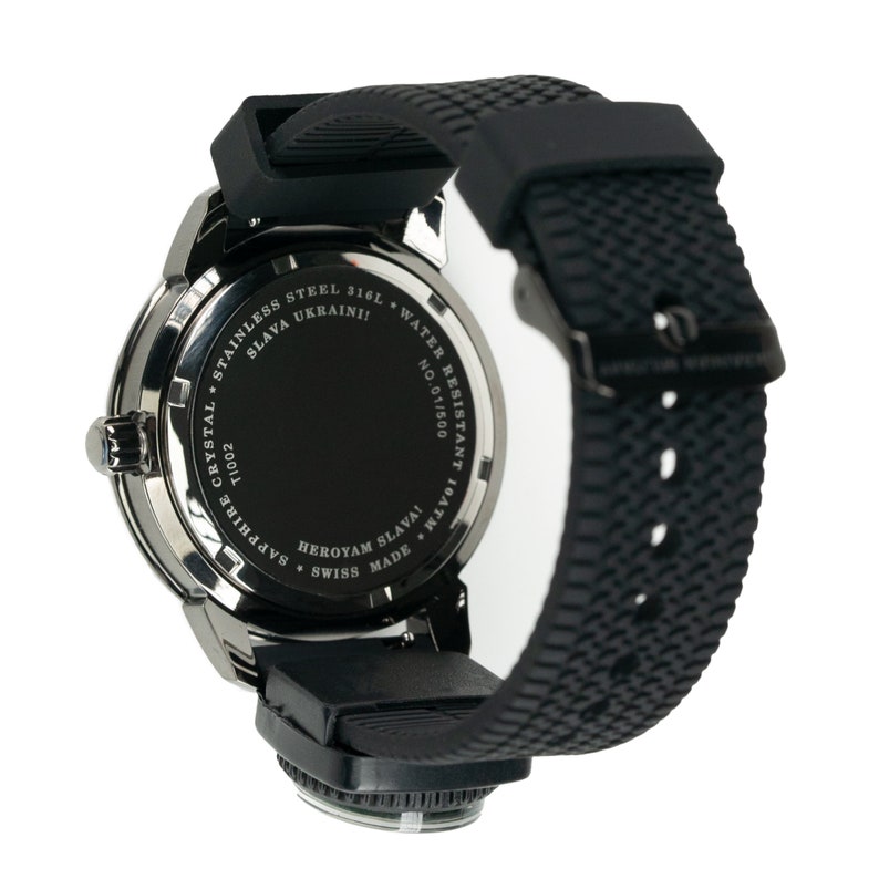 May include: Black wristwatch with a black rubber band. The back of the watch has the text "SLAVA UKRAINI!" and "HEROYAM SLAVA!" in white lettering. The watch is water resistant to 10 ATM.