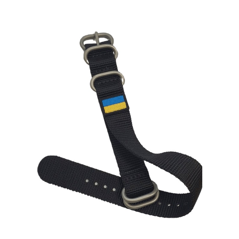 May include: Black watch strap with silver hardware and a small Ukrainian flag.