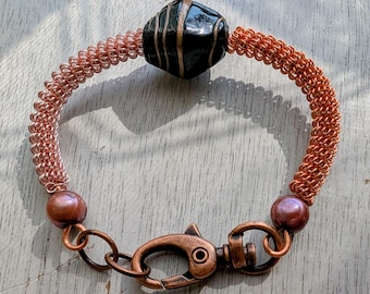 Bracelet en fil de cuivre torsadé fait main : perles de verre noires et dorées et perles mauves