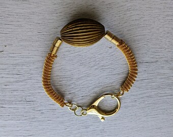 Ambiance art déco ! Bracelet en fil de fer enroulé doré avec pièce maîtresse en laiton