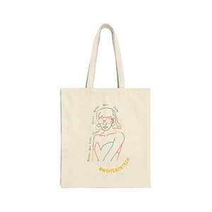 May include: A beige tote bag with a colourful line drawing of a woman wearing glasses and the text "Girls Who Code, Women Who Code, Coder, Who Code, Women,  #WomenInTech".