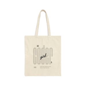 May include: A beige tote bag with the text "BE coder girl" printed in black. The text is styled with the letters "coder" stacked on top of each other. The bag has a short description below the text that reads "A girl with magical powers who can hack your day".