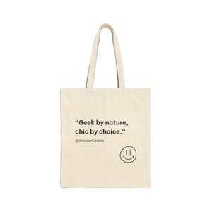 May include: A beige tote bag with the text "Geek by nature, chic by choice." and the Twitter handle "@WonderCoders". A simple smiley face is below the text.