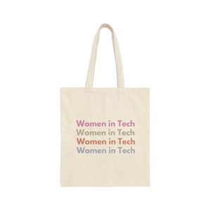 May include: A beige tote bag with the text "Women in Tech" repeated four times in different colours: pink, orange, yellow, and blue.