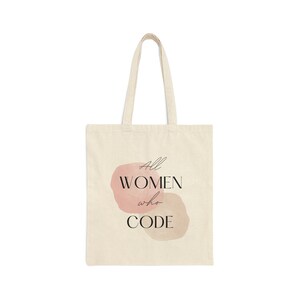 Op de afbeelding: Een beige tote bag met een roze aquarelontwerp en de tekst "All WOMEN who CODE".