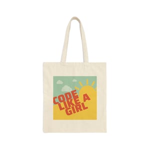 May include: A white tote bag with a yellow, green and orange graphic design. The graphic features a sun and the text "CODE LIKE A GIRL".