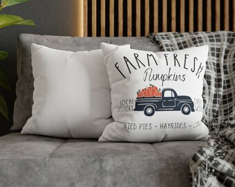 Puede incluir: Dos almohadas blancas con texto negro que dice "Farm Fresh Pumpkins" con un camión negro que lleva calabazas naranjas. El texto también dice "Local Delivery, Every Week, Fried Pies, Hayrides, Cider".