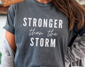 Koszulka Stronger Than The Storm Comfort Colors®, koszulka z wersetem biblijnym, motywująca odzież chrześcijańska, koszulka unisex, inspirująca koszulka na prezent