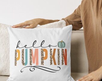 May include: White throw pillow with the text "hello pumpkin" in colorful letters with a leopard print pattern. The letters are outlined in black and the word "pumpkin" has a small blue pumpkin graphic above it.