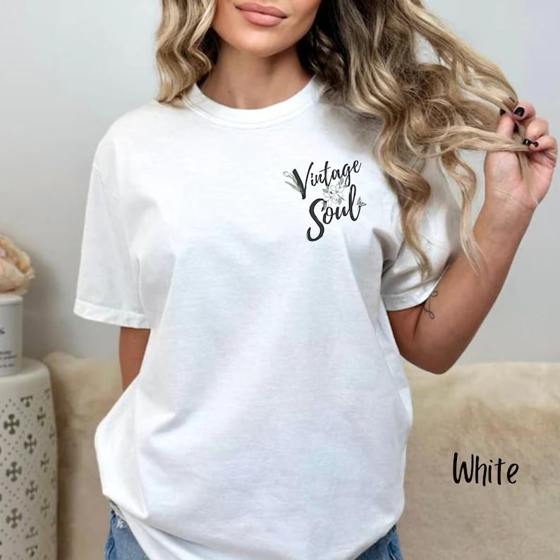 May include: White t-shirt with a floral design and the text "Vintage Soul" printed on the front.