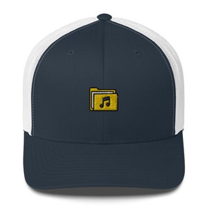 Puede incluir: Una gorra de camionero azul marino y blanca con un icono de carpeta amarillo que contiene una nota musical. La gorra tiene una parte trasera de malla.