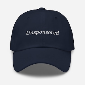 May include: A navy blue baseball cap with the word "Unsponsored" embroidered in white on the front.