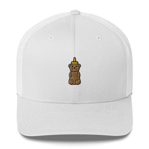 Puede incluir: Gorra de camionero blanca con un oso de gominola marrón que lleva un sombrero de botella de mostaza amarilla.