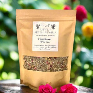 Könnte beinhalten: Ein brauner Papierbeutel mit einem Etikett, auf dem steht "Angel's Apoth-a-Fairy Healing from the inside out Moonflower PMS Tea A natural way to help alleviate PMS symptoms, to enjoy your day and have a good night's sleep". Der Beutel enthält eine Mischung aus getrockneten Kräutern und Blüten.