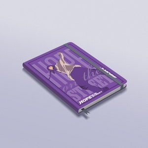 Puede incluir: Cuaderno morado con un gr&aacute;fico de una persona bailando y el texto "HOPE on the STREET" en blanco. El cuaderno tiene una banda el&aacute;stica morada y un marcador de cinta morado.