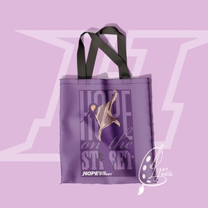 Puede incluir: Bolsa de tela de color morado con un gr&aacute;fico de una persona bailando y el texto "HOPE on the STREET" y "HOPE STREET".