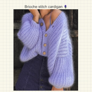 Könnte beinhalten: Ein fliederfarbener Brioche-Strickcardigan mit Holzknöpfen und Ballonärmeln. Der Cardigan hat einen V-Ausschnitt. Der Text "Brioche stitch cardigan" befindet sich oben im Bild.